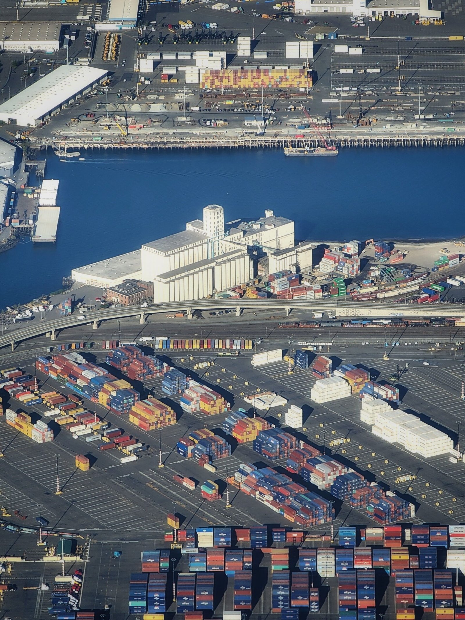 Insights High-angle aerial view of a bustling shipyard filled with colorful cargo containers and facilities.