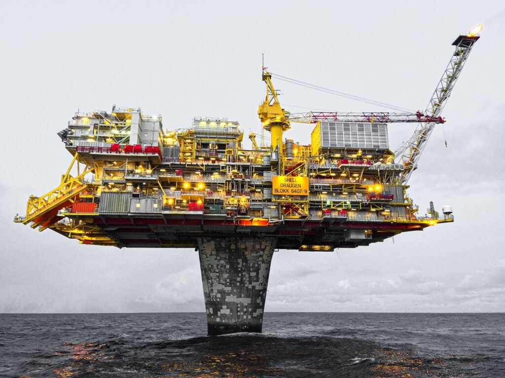 project-1 A well-lit offshore oil platform against a cloudy sky in Norway's waters.