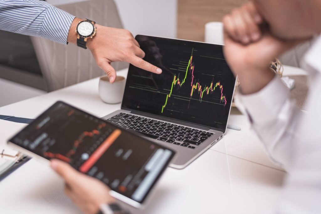 project-4 Business professionals analyzing cryptocurrency market trends on laptop and tablet.