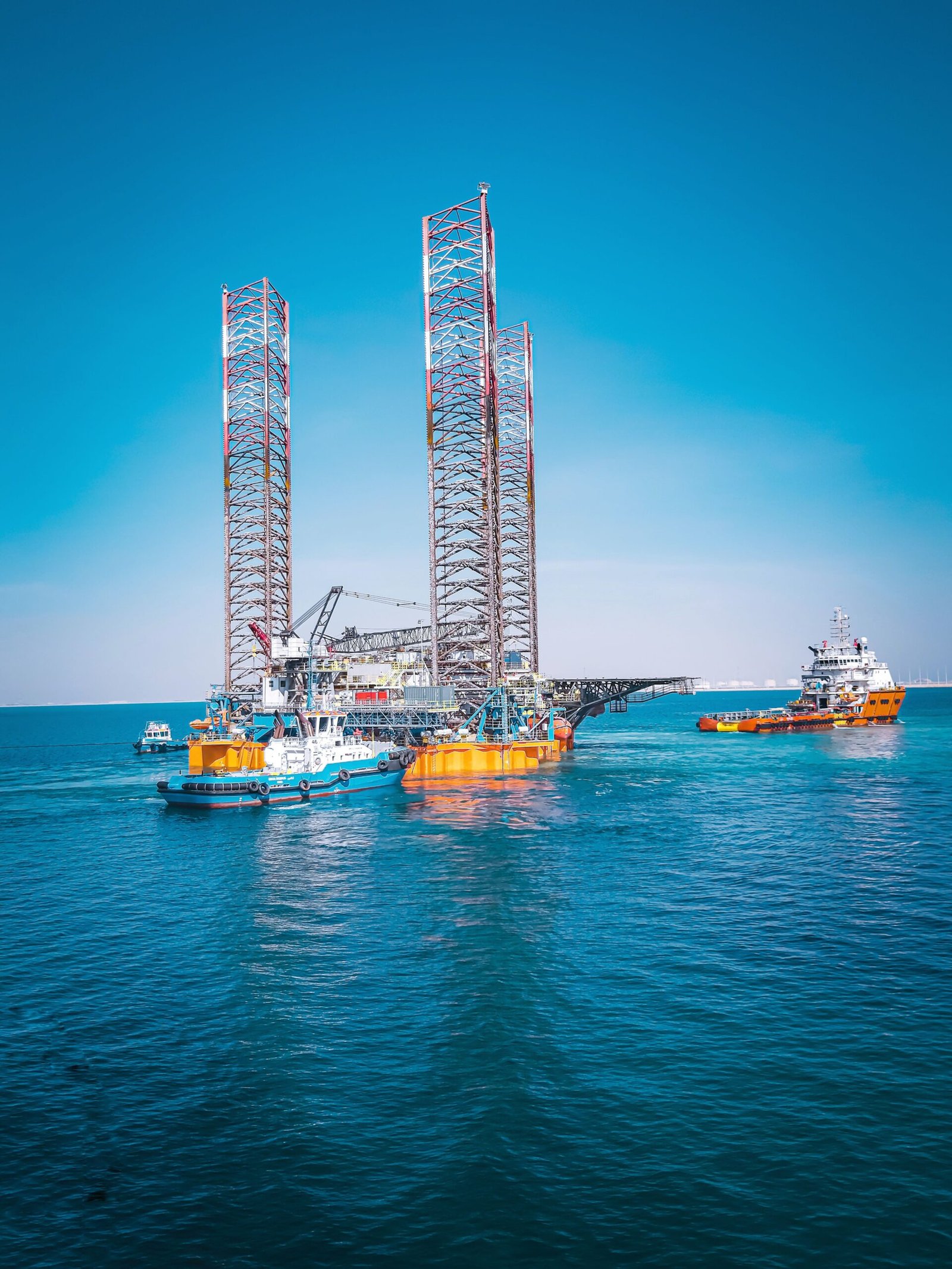 automotive Offshore oil rig and support vessels in Ras Laffan, Qatar under clear blue sky.